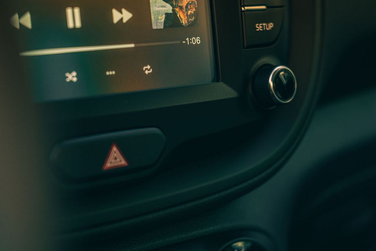 A vehicle dashboard and stereo controls at dusk