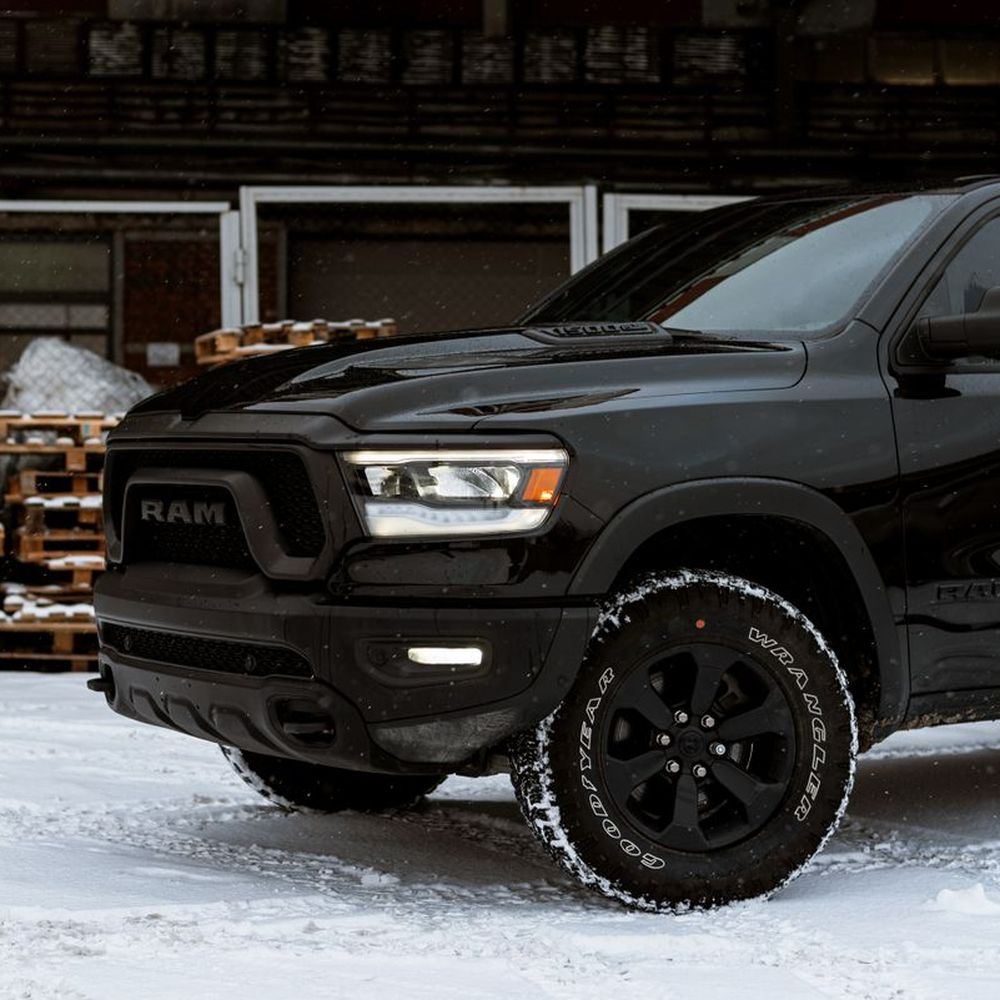A dark pickup truck parked outside a workshop